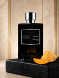 SOVRAI Maturus 100ML extrait de parfum bottle on a black wooden pedestal with pineapple and mango accents.