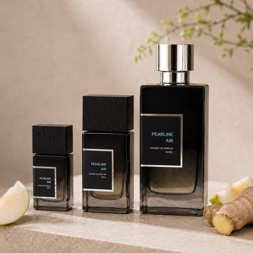 SOVRAI Pearline Air perfume size lineup with 30 mL, 50 mL and 100 mL extrait de parfum bottles beside pear and ginger on a warm neutral studio background.